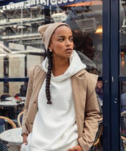 Model wearing Lula Beige Beanie Mallory the Label with white hoodie and camel coat