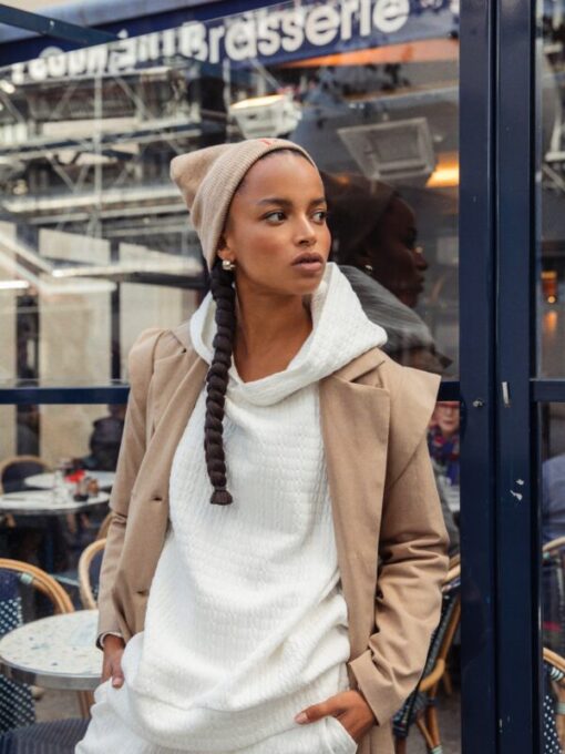 Model wearing Lula Beige Beanie Mallory the Label with white hoodie and camel coat