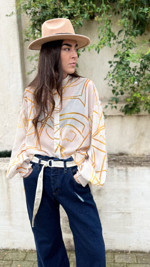 Model wearing oversized printed shirt with gold pattern and dark denim pants-IGO PROJECT