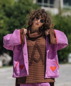 Model wearing The Wait Sweatshirt with pink jacket and mini skirt by Atheras Clothing